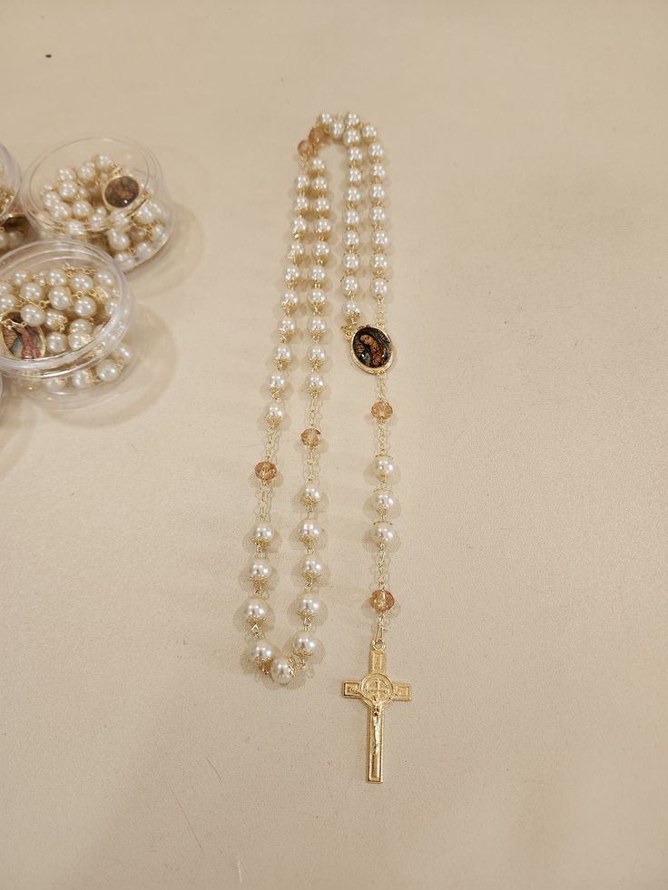 A Beautiful Rosary that makes the perfect gratitude gift to your guests in your special event or as a gift made by the godparents. Usually bought with a bible or by itself, this rosary is ideal to pray and keep as a memory from your special celebration.   12 pieces  Made out of metal and pearls (20 in. long approx)   *PLEASE NOTE THAT SLIGHT COLOR DIFFERENCE SHOULD BE ACCEPTABLE DUE TO LIGHT ENVIRONMENT AND MONITOR SCREEN* Elegant Pearl Rosary With Cross, Spiritual Pearl Rosary With 8mm Beads, Elegant Pearl Rosary For First Communion, Elegant Cross Rosary For First Communion, Spiritual Pearl Rosary As Gift, Pearl Rosary For First Communion, Spiritual Style, Spiritual Pearl Rosary For First Communion, Pearl Rosary With Round Beads As Gift, Pearl Rosary With 8mm Beads As Gift