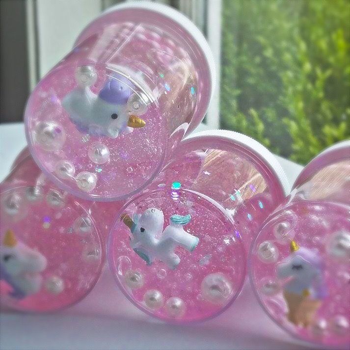 four plastic cups with unicorns and stars on them sitting in front of a window