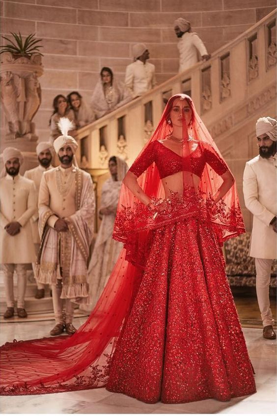 a woman in a red gown standing next to other people