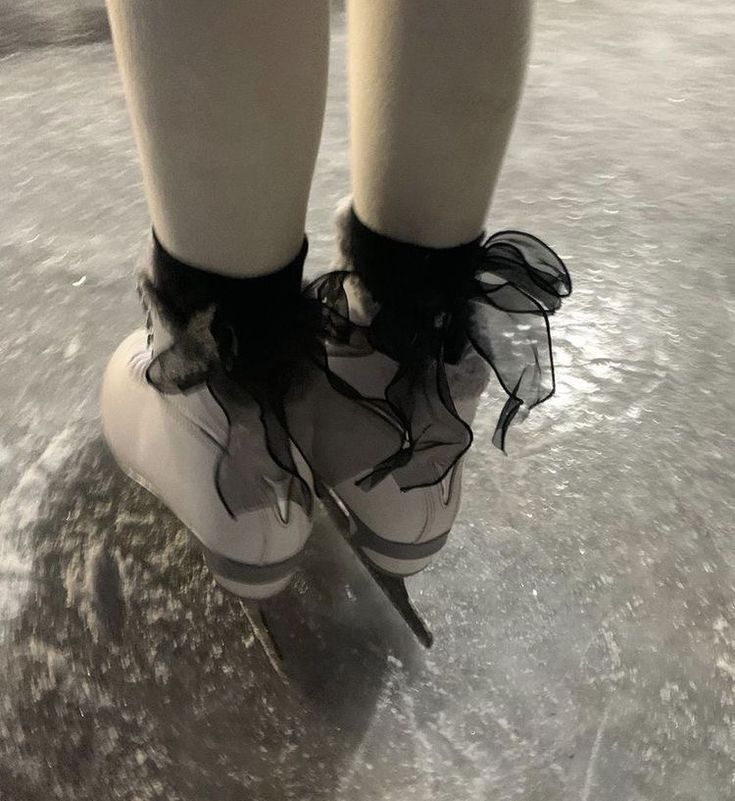 the legs and feet of a person on ice skates