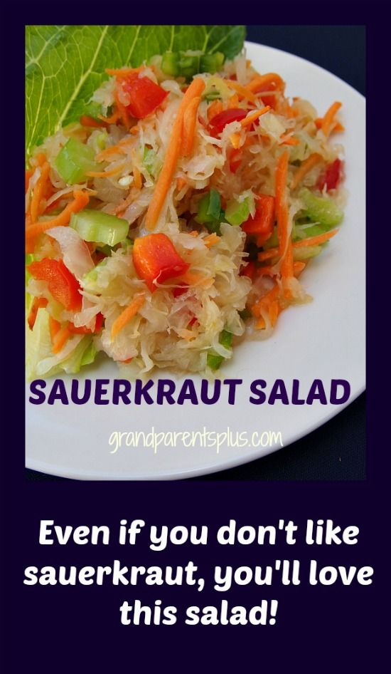 a white plate topped with coleslaw and carrots next to a green leaf