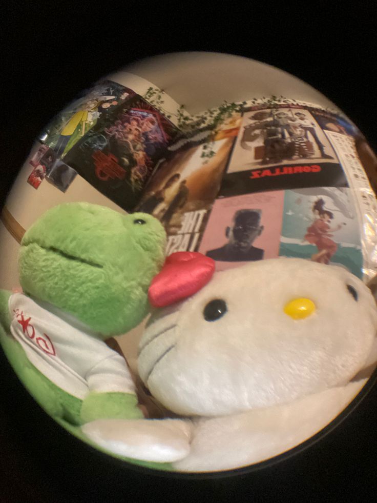 two stuffed animals sitting next to each other in front of a plate with pictures on it