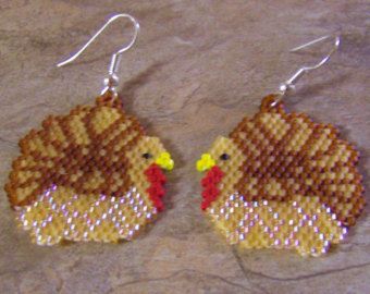 a pair of beaded turkey earrings sitting on top of a table