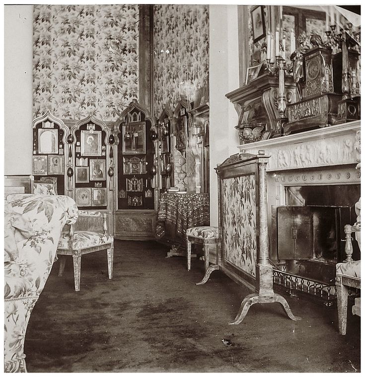 an old black and white photo of a living room with chairs, fireplace and wallpaper