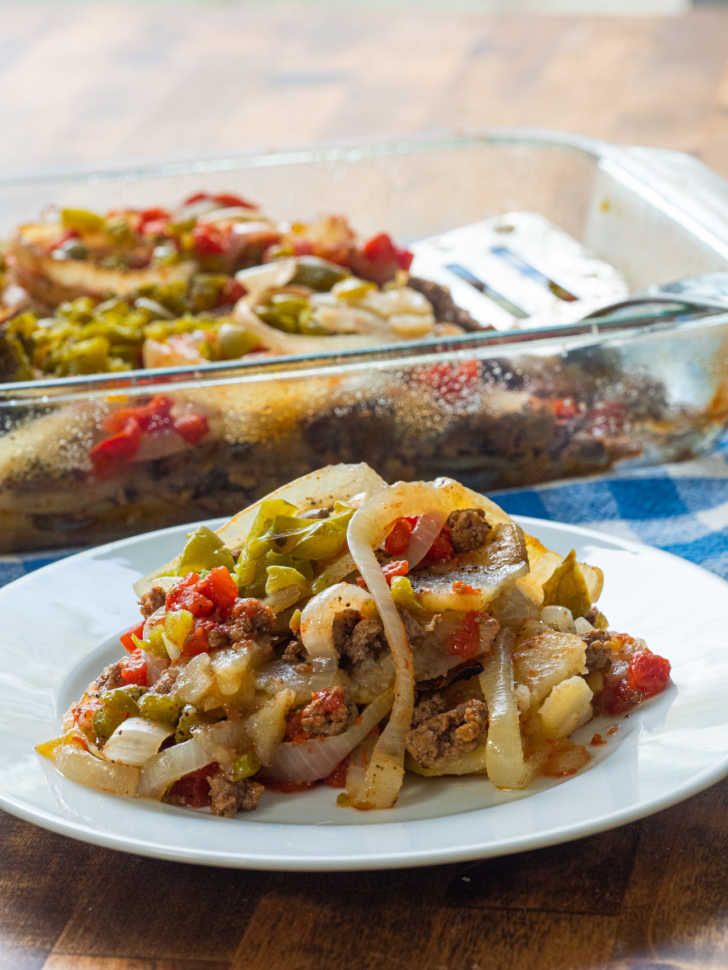 a white plate topped with food next to a casserole dish filled with vegetables