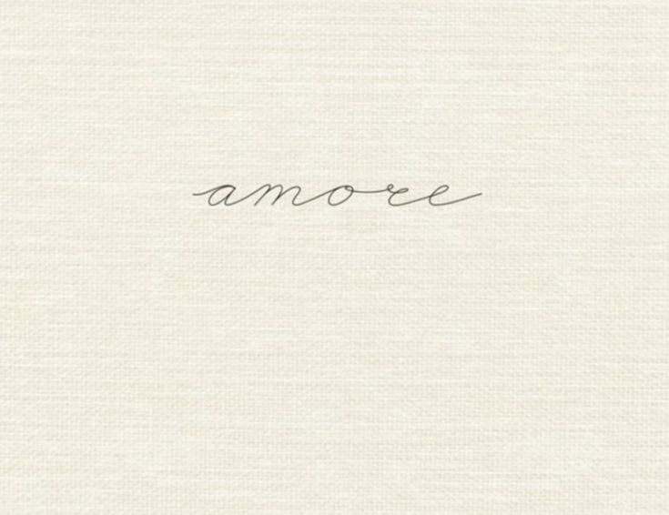 the word amore written in cursive handwriting on a white paper background with black ink