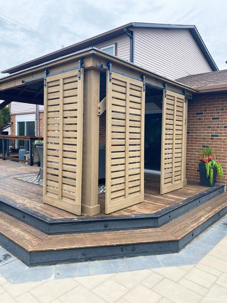 a large wooden structure with shutters on the front and side of it is shown