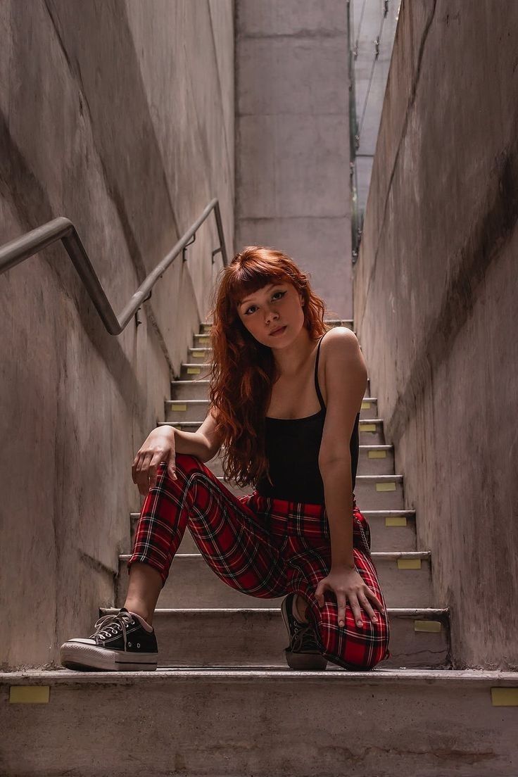 a woman is sitting on the stairs with her legs crossed