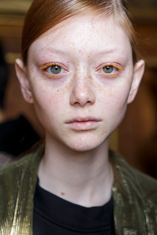 a woman with freckles on her face and hair is looking at the camera