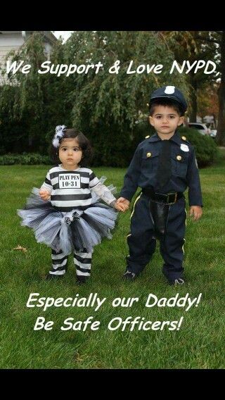 two children dressed up as police officers holding hands