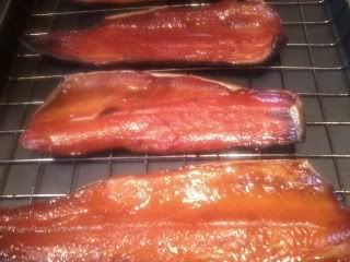 three pieces of bacon cooking on a wire rack