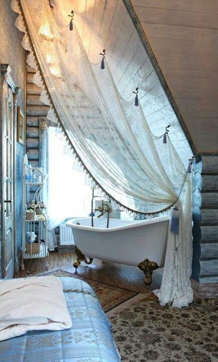 an old fashioned bathtub in the corner of a room with sheer curtains on it