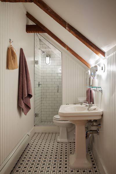 a bathroom with a sink, toilet and shower stall in the corner on the wall