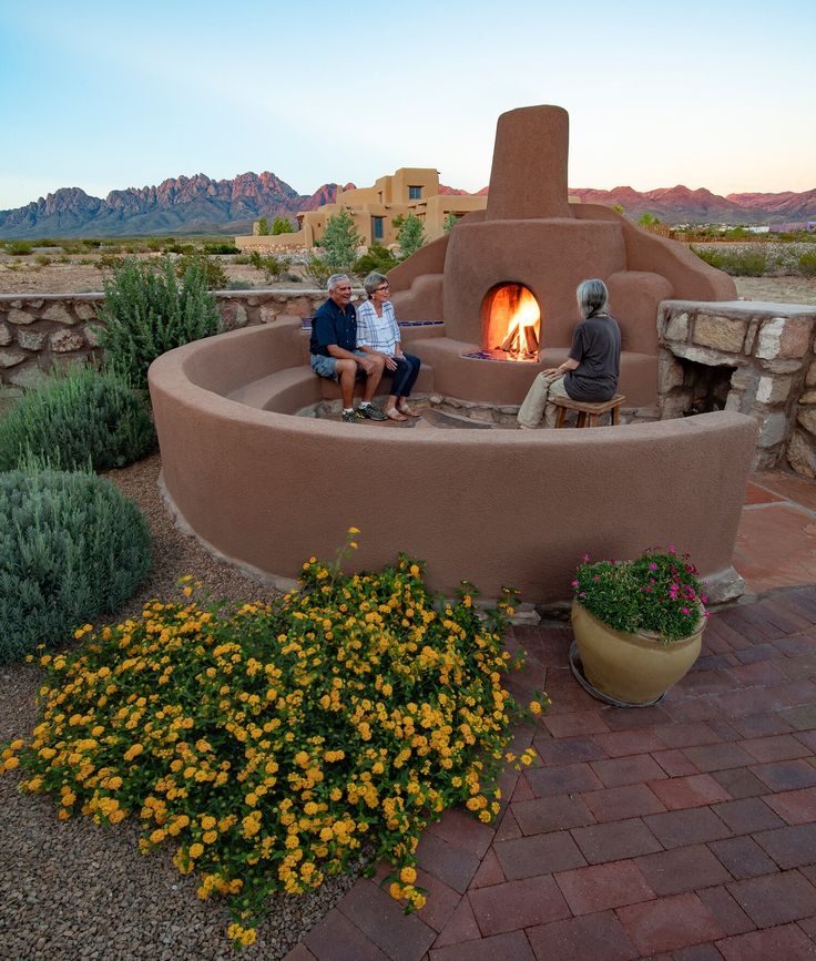 two people sitting in front of an outdoor fireplace