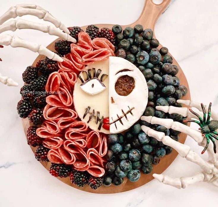 a cake decorated to look like the face of jack skellingy with fruit and bones