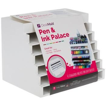 a stack of pens and inks on display in a white cardboard holder with dividers