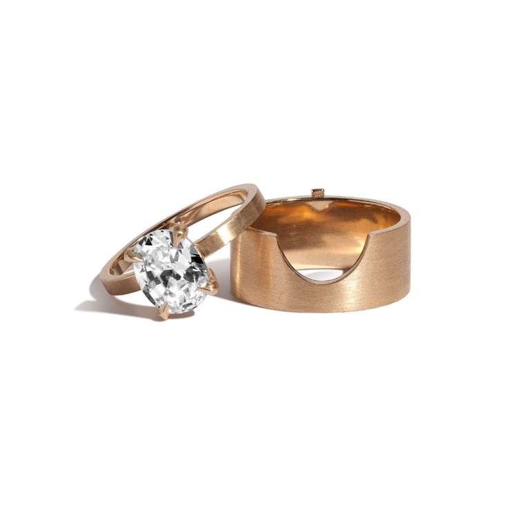 two gold wedding rings with a diamond in the middle