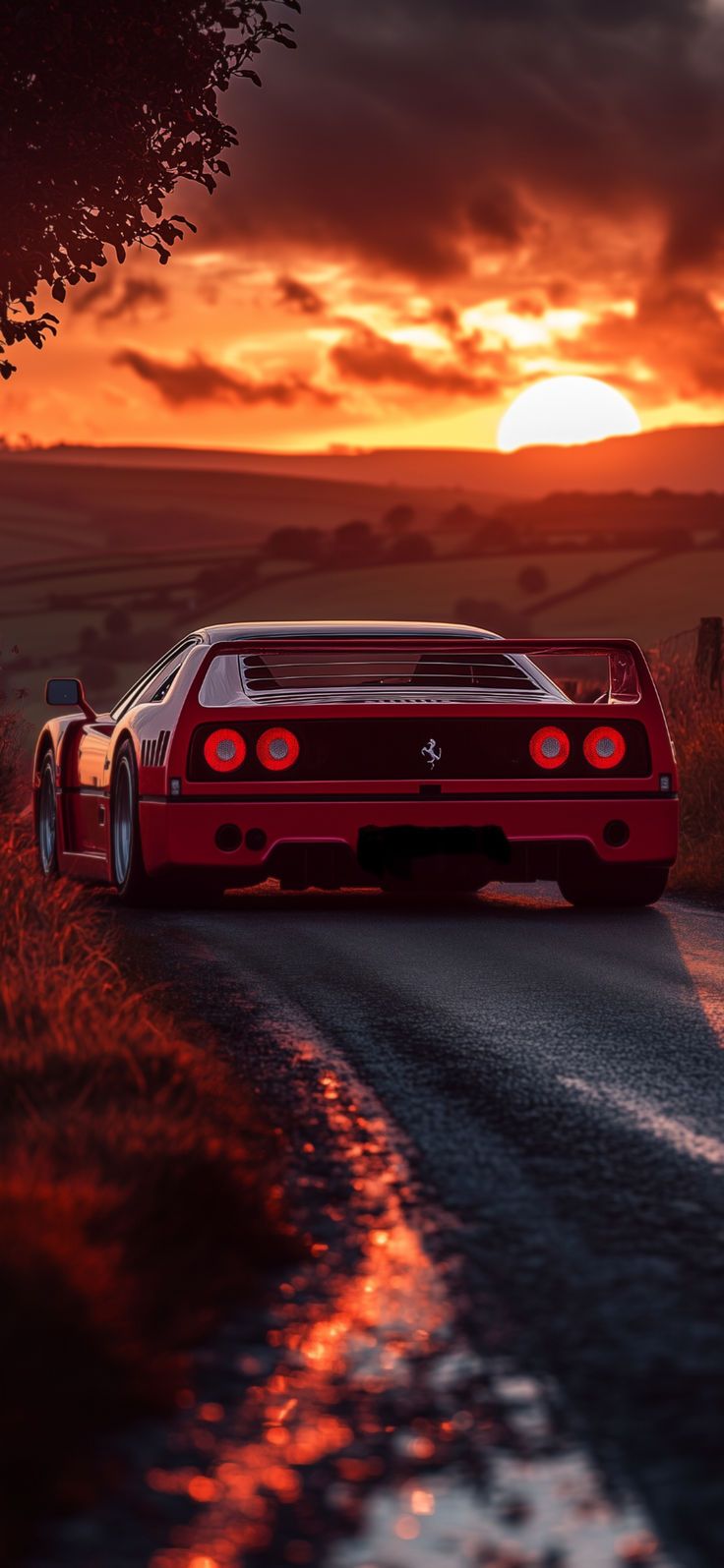 a red sports car driving down a country road at sunset with the sun in the background