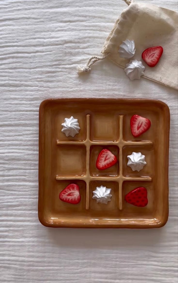 strawberries are arranged in an ice tray on a white tablecloth with two napkins