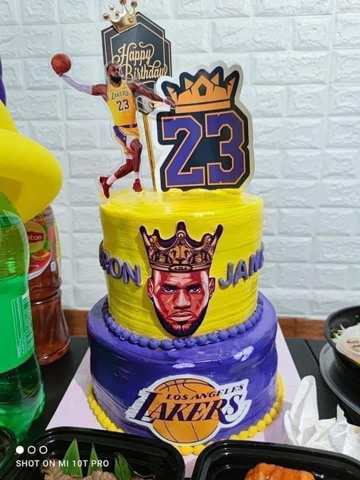 a three tiered cake decorated with the number 23 and lakers on it's side