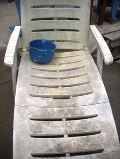 an old white chair with a blue bowl sitting on it's backrests