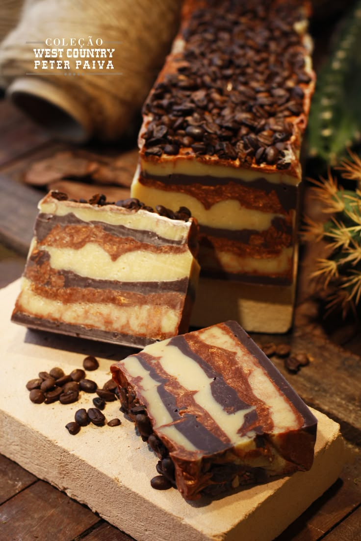 three pieces of cake sitting on top of a wooden cutting board next to coffee beans