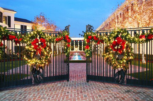 christmas wreaths are hung on the gates at this gated entrance