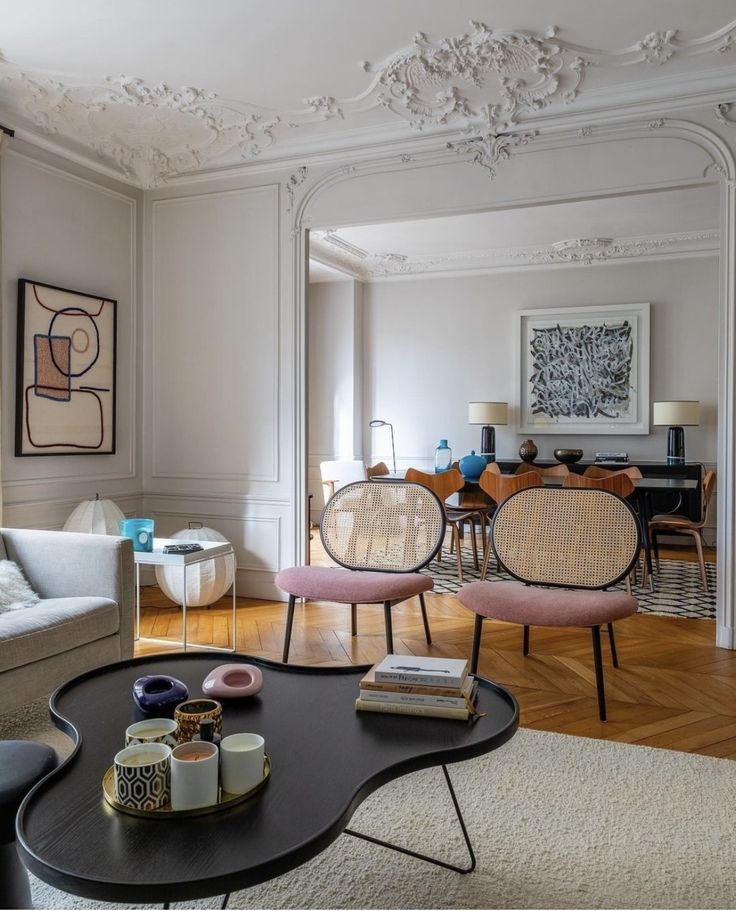 a living room filled with furniture next to a dining room table and chairs on top of a hard wood floor