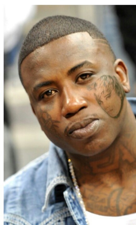 a man with tattoos on his face looking at the camera