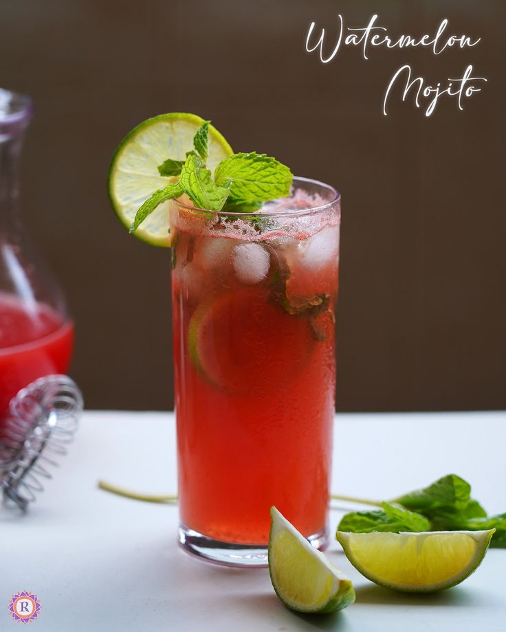 a tall glass filled with watermelon mojita next to sliced limes