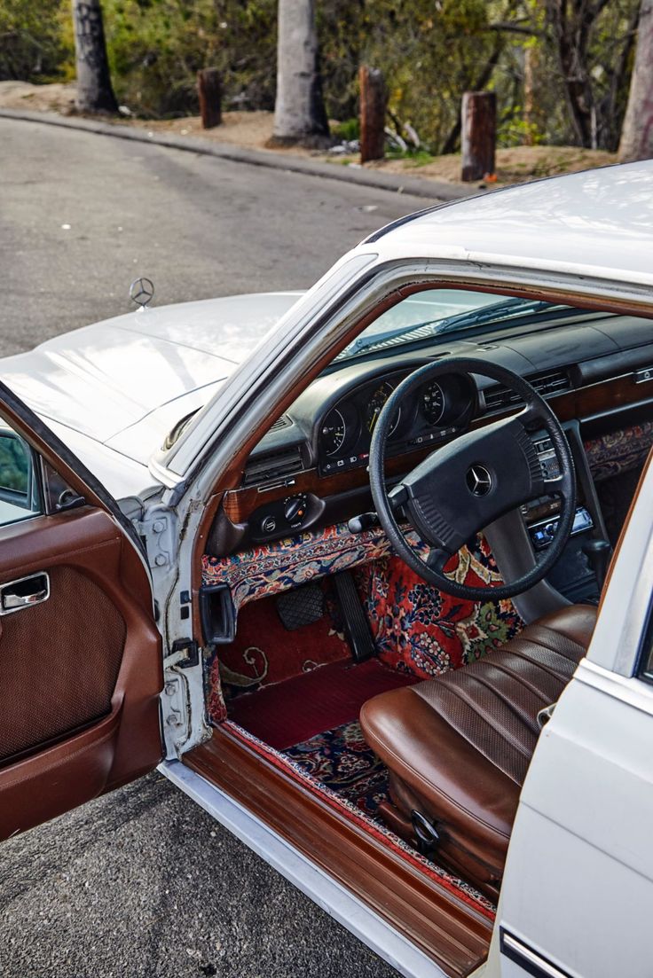 the interior of a car with its door open and leather seats folded down on the floor