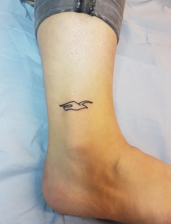 a woman's foot with a small tattoo on her left ankle and the word love written in cursive writing