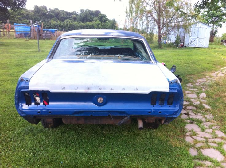 an old blue and white car sitting in the grass