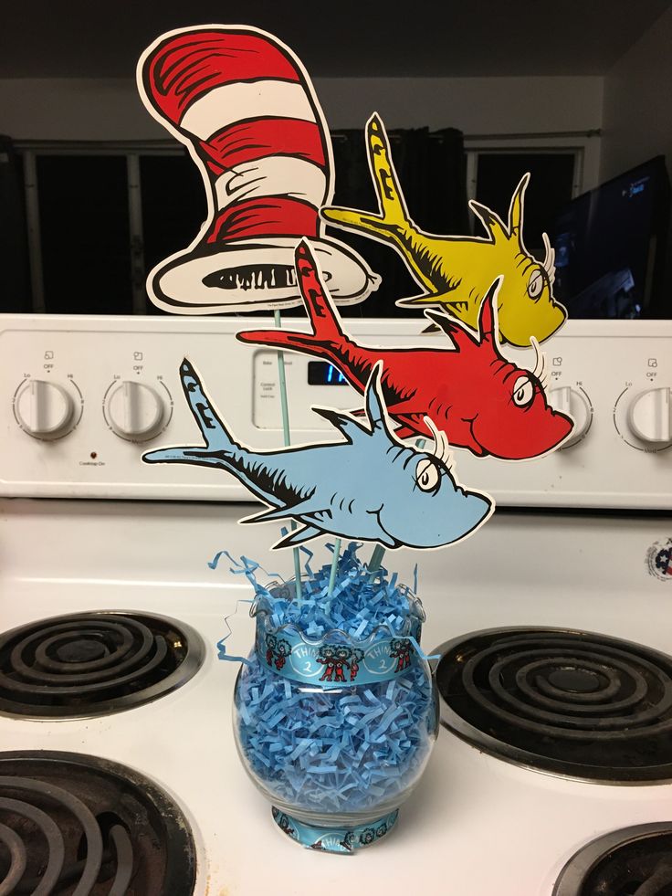 a cat in the hat cake topper sitting on top of a stove with blue frosting