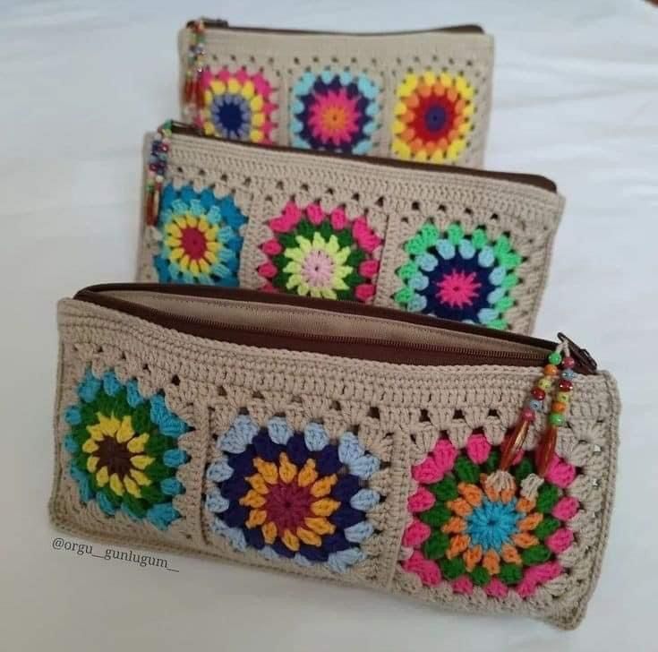 three crocheted purses sitting on top of a bed