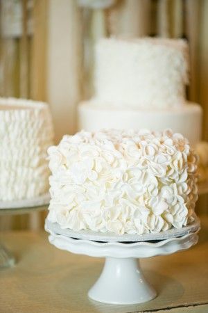 two white cakes sitting on top of a table