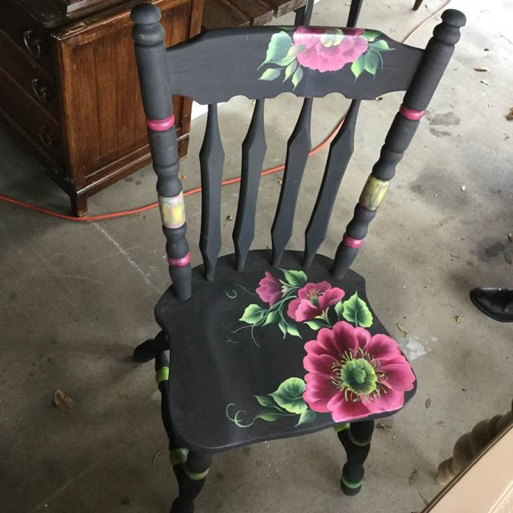 an old chair with flowers painted on it