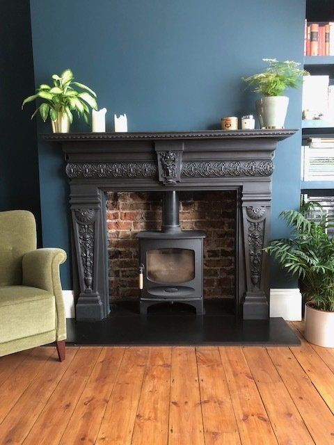 a living room with a fire place and a chair in front of the fireplace that is painted blue