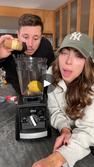 a man and woman are making something in a blender