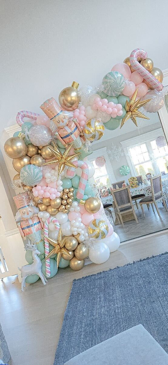 the balloon arch is decorated with pink, gold and white balloons