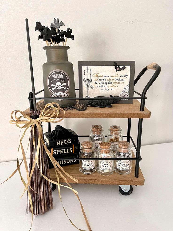 an assortment of halloween items on a shelf with a sign and some decorations in the background