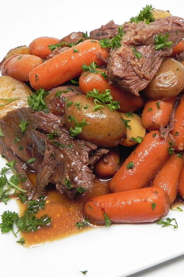 a white plate topped with meat and carrots