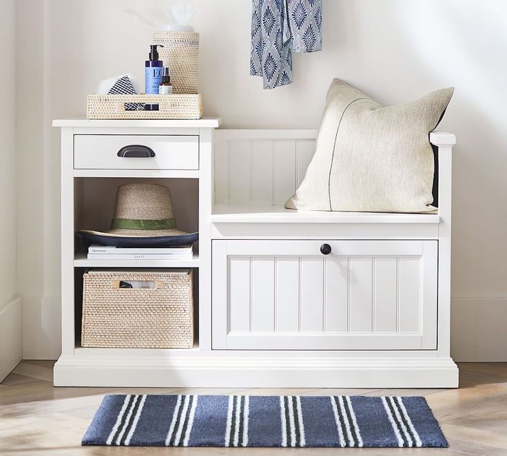 a white bench with baskets and towels on it