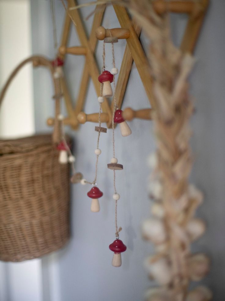 a wind chime hanging from a wooden pole next to a wicker basket on the wall