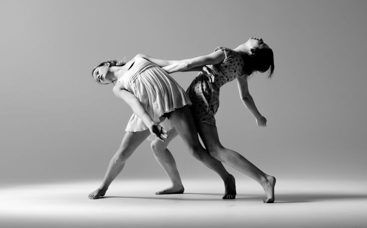 two people are dancing in the middle of a dance studio photo by person, who is holding on to her leg