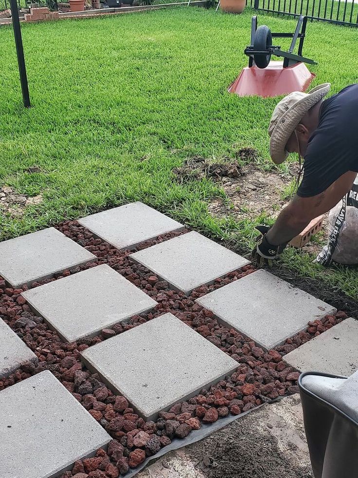 a man is laying stones on the ground