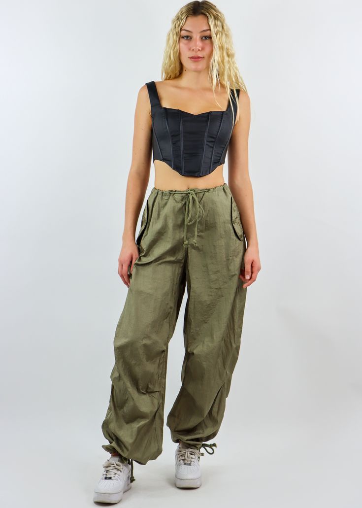 We are obsessed with these must have parachute pants! They feature an adjustable waist and ankle detailing with an oversized fit throughout the body. They are the most comfortable and trendy bottoms in fashion right now, and we can't wait to see you rock them! Wear them with your favorite crop top or oversized hoodie. Model Info Meet Zoe! Here she is wearing a size small. Hips: 35” | Waist: 25” | Bust: 32” | Height: 5’7” The Details Parachute Pants Adjustable Waist Adjustable Ankle Hand Wash Col Khaki High-waisted Cargo Parachute Pants, Military Style Relaxed Fit Wide Leg Parachute Pants, Summer Streetwear Relaxed Fit Parachute Pants, Spring Combat Cargo Pants For Streetwear, Spring Military Style Parachute Pants With Cargo Pockets, Spring Military Parachute Pants With Cargo Pockets, Spring Military Cargo Pants For Streetwear, Combat Nylon Pants With Cargo Pockets, Khaki High Waist Utility Parachute Pants