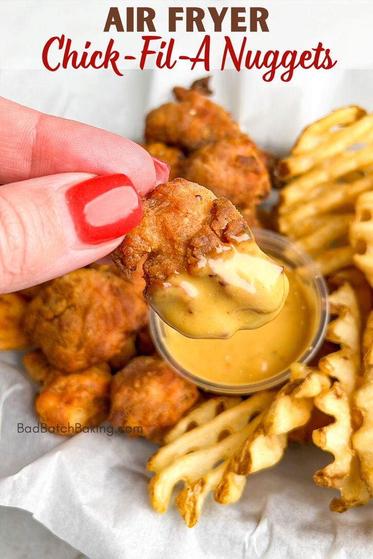 a person dipping sauce on chicken nuggets in a small bowl with the words air fryer chick - fil - a nuggies