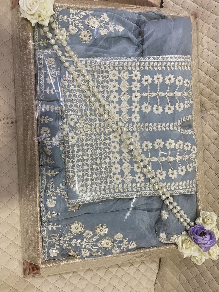 a piece of cloth with flowers on it sitting on top of a quilted surface