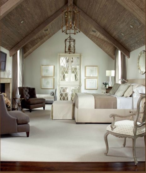 a large bedroom with white carpeting and wooden beams on the ceiling is decorated in neutral colors